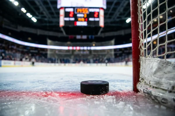 Disco de hockey sobre hielo con marcador mostrando diferencia de goles en partido NHL